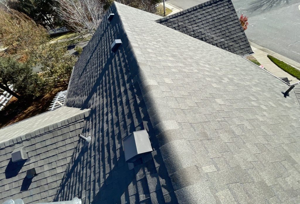 Finished gray shingle hip roof with ridge vents in Centennial, Colorado.