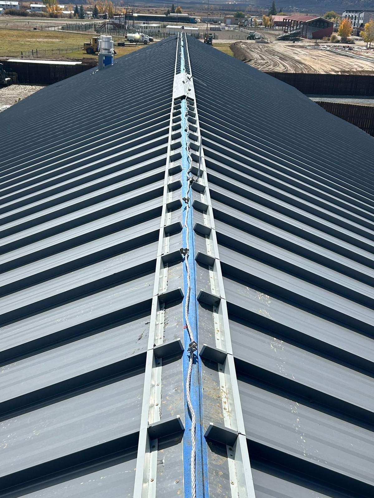Commercial standing seam metal roof ridge during installation in Gunnison, CO