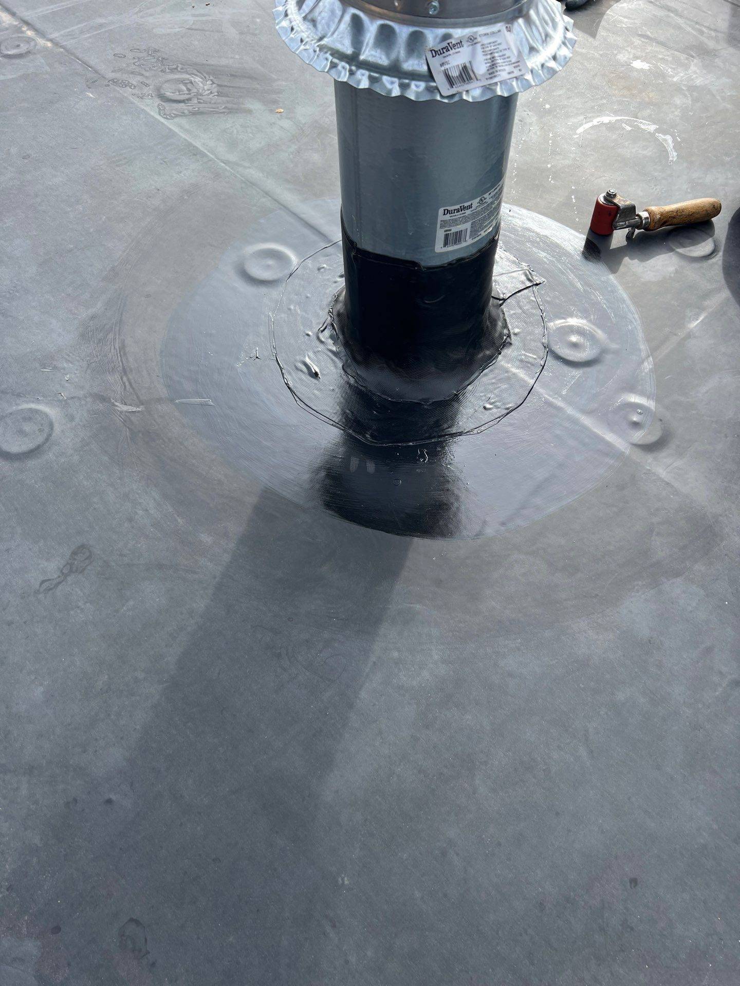 Vent pipe flashed into a fully adhered EPDM membrane with a membrane boot