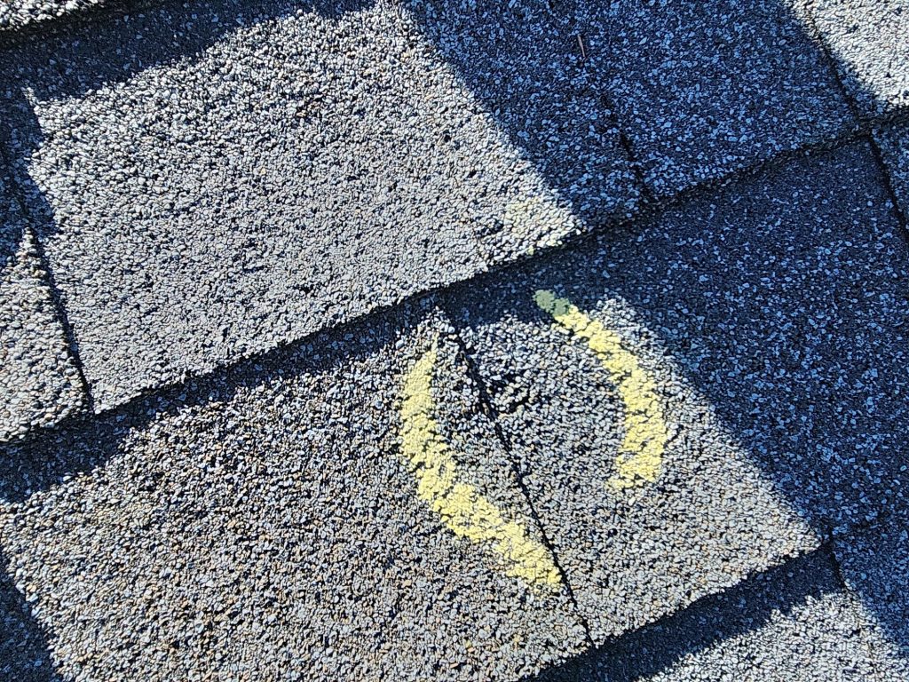 Hail impact circled in chalk during a roof inspection in Arvada, Colorado.