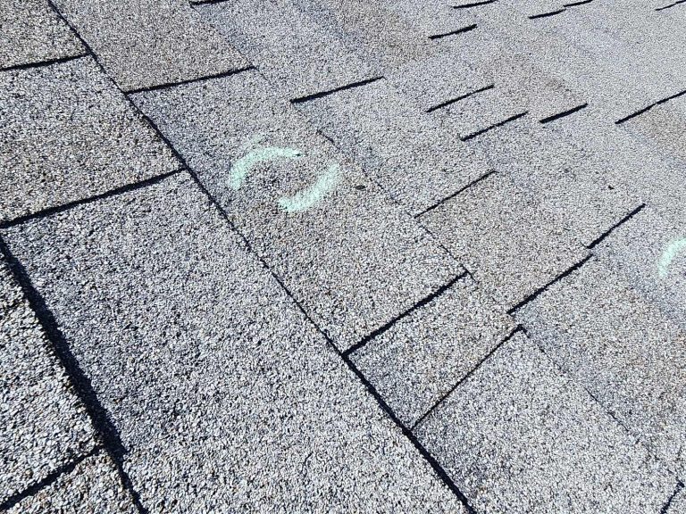Several chalk-marked hail hits across asphalt shingles in Arvada, CO