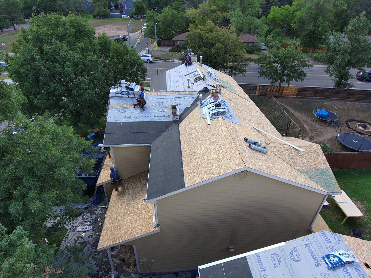 Underlayment going down on a multifamily townhome roof before Atlas Pinnacle Impact shingles in Fort Collins, CO