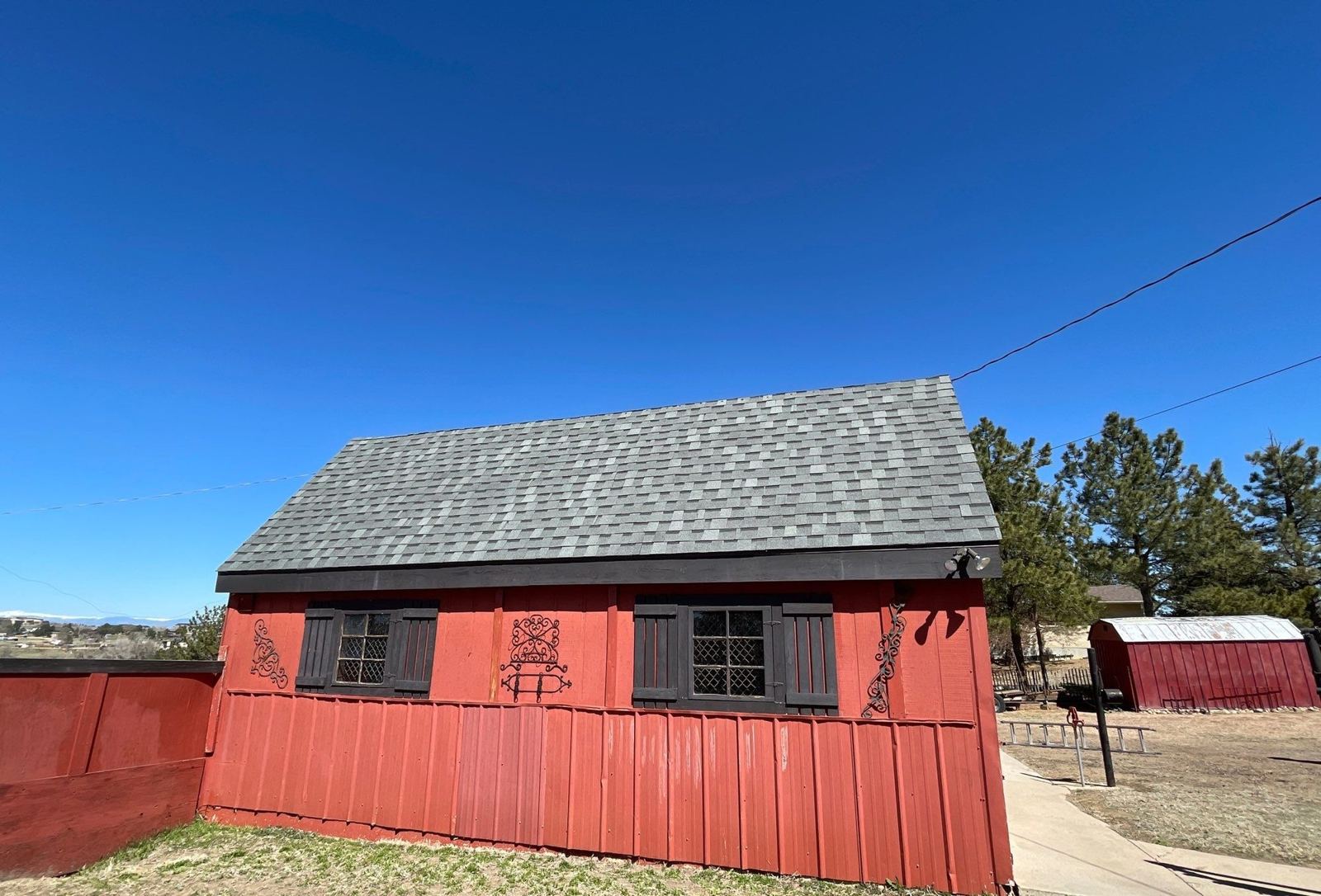 Atlas impact-resistant shingle roof on a red outbuilding in Parker, CO