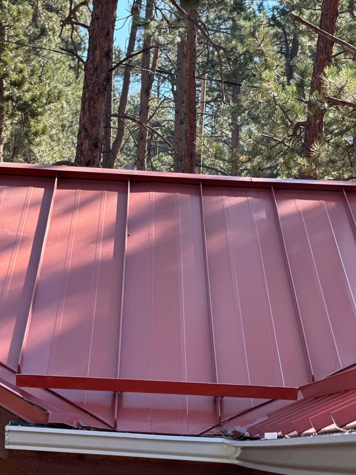Standing seam metal roof with snow retention bar in Indian Hills, CO