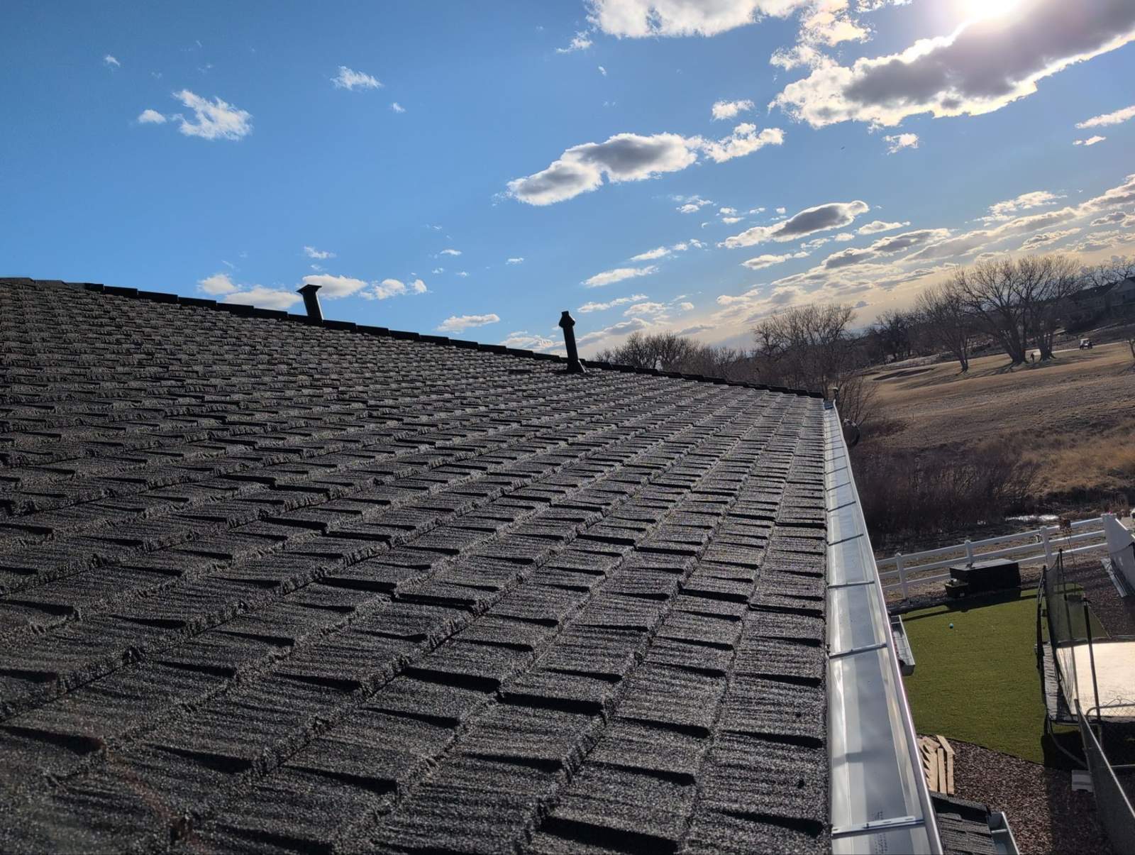 Finished Westlake Royal stone-coated steel roof in Charcoal on a Front Range home under a blue sky