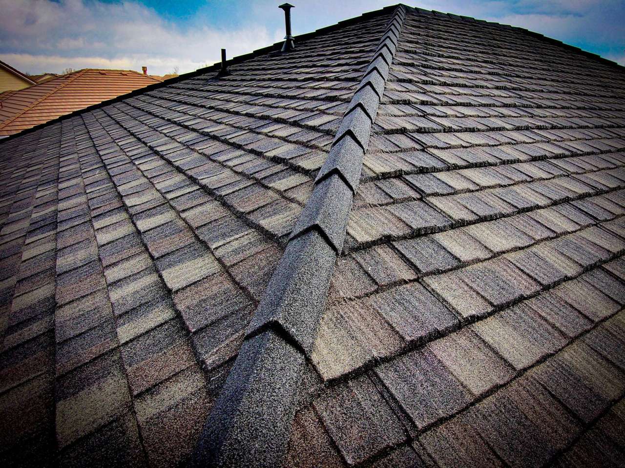 Westlake Royal Cap Shake ridge on a stone-coated steel roof with Cottage Shingle panels in Charcoal