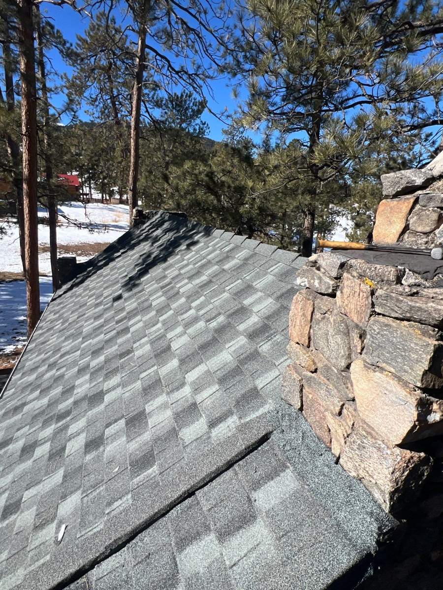 Iron Wood stone-coated steel Cottage Shingle panels tied into a fieldstone chimney
