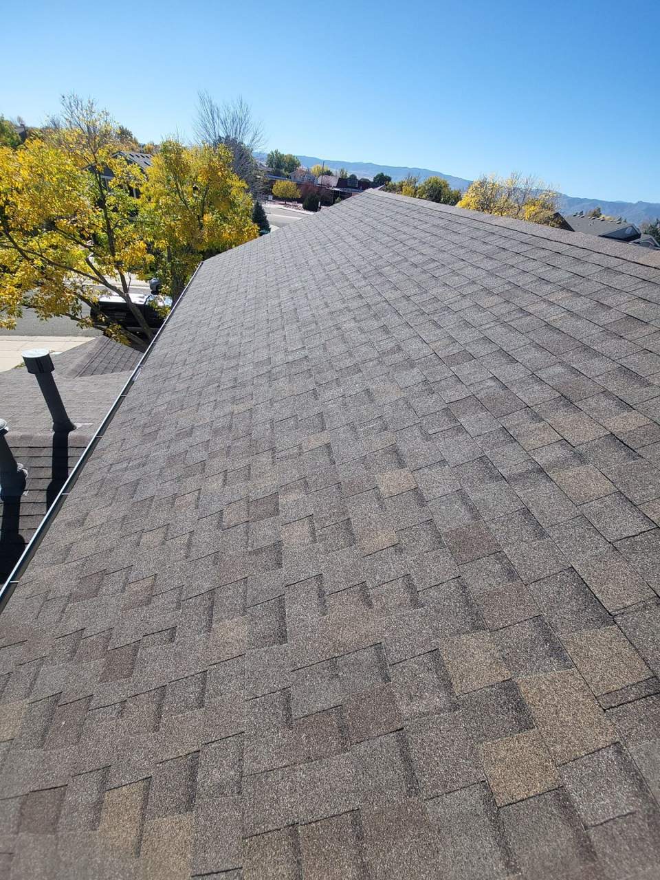 TAMKO StormFighter FLEX shingle roof in Rustic Slate with fall trees behind