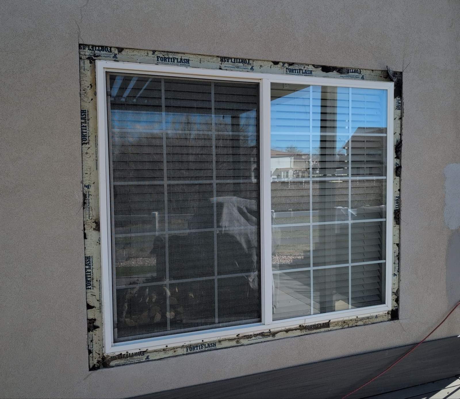 Stucco cut back and opening flashed around an old slider window before removal