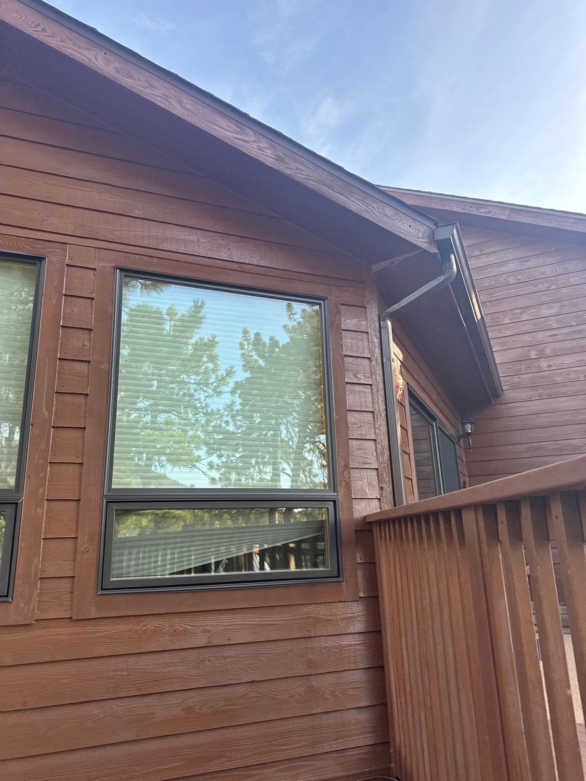 New picture window over an awning window in stained cedar siding